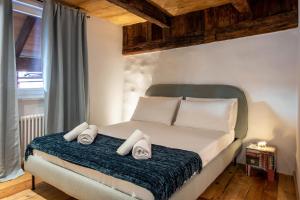 een slaapkamer met een bed met twee handdoeken erop bij Boznerhütte - La Baita Bolzano in Bolzano