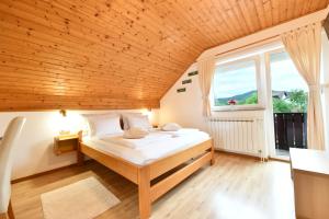 ein Schlafzimmer mit einem Bett und einem großen Fenster in der Unterkunft House Marija B&B in Selište Drežničko