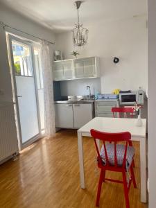 a kitchen with a white table and a red chair at Apartments Taci in Bled