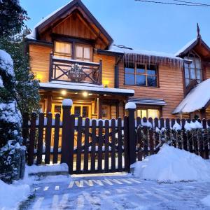 a wooden house with a fence in front of it at Ushuaia Lodge Las Margaritas 430 in Ushuaia