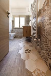 a bathroom with a tub and a tile floor at Blue Apartment Messina in Messina