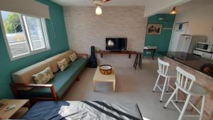 a living room with a couch and a kitchen at RETIRO DA VILA , você no coração de Ilhabela in Ilhabela