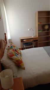 a bedroom with a bed with a desk and a lamp at LC Gavín - PARKING GRATIS in Zaragoza