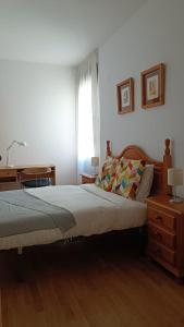 a bedroom with a bed and a desk and a window at LC Gavín - PARKING GRATIS in Zaragoza