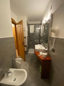 a bathroom with a sink and a toilet and a shower at Hotel Bait de Angial in Livigno