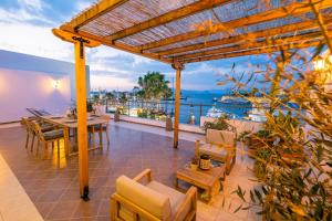 a patio with a table and chairs and a view of the water at Attico Blu - Sea View Penthouse in Kos Town