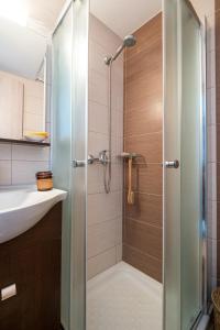 y baño con ducha y puerta de cristal. en Attico blu - Sea View Penthouse, en Cos
