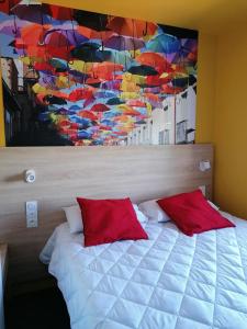 a bedroom with a bed with a painting of umbrellas at Kyriad Direct Martigues in Martigues