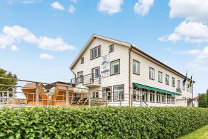 a large white building with a fence in front of it at Hotell Nordevik in Skärhamn