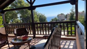 eine Veranda mit 2 Stühlen und einem Tisch auf dem Balkon in der Unterkunft Villa Maira in Afytos