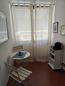 een kamer met een tafel en stoelen en een raam bij La Casa del Sole in Fresonara