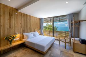 a bedroom with a bed and a large window at THESIS VILLAS in Skala Potamias