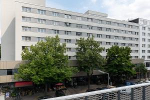 biały budynek z drzewami przed nim w obiekcie SORAT Hotel Berlin w Berlinie