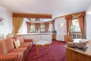 ein Wohnzimmer mit einem Sofa und einem Tisch in der Unterkunft Naturhotel Waldheim in Anterivo