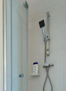 a shower with a shower head in a bathroom at The Merryburn - Rooms and Courtyard Studios in Dunkeld