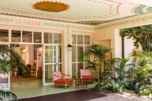a lobby with chairs and a table and a ceiling at Hôtel La Tartane Saint-Tropez in Saint-Tropez