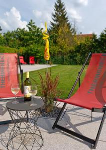 ラー・アン・デア・ターヤーにあるAppartementhaus Thermeneckのテーブル(椅子2脚付)とワイン1本
