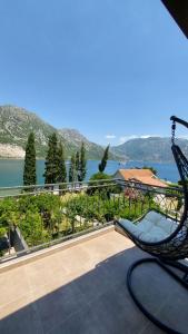 einen Stuhl auf einem Balkon mit Blick auf das Wasser in der Unterkunft Apartments Đule in Donji Morinj