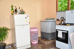 een keuken met 2 koelkasten en een vuilnisbak bij Homestay Orchid in Mahawatta