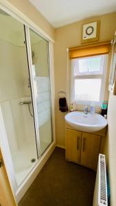 ein Badezimmer mit Waschbecken und Dusche in der Unterkunft Ferienhaus Vienna am Kronensee in Ostercappeln
