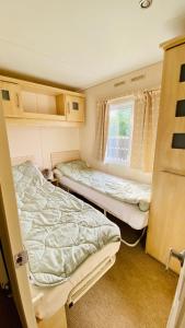 ein kleines Zimmer mit zwei Betten und einem Fenster in der Unterkunft Ferienhaus Vienna am Kronensee in Ostercappeln
