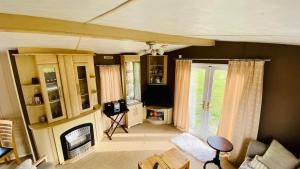ein Wohnzimmer mit Couch und Fernseher in der Unterkunft Ferienhaus Vienna am Kronensee in Ostercappeln