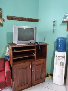 uma televisão num centro de entretenimento de madeira com uma televisão em Salinópolis - Apartamento Varandas do Atlântico em Salinópolis