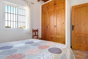 een slaapkamer met een bed en een houten kast bij Casita Torre de Meca 1 Sin Piscina in Los Caños de Meca +18 foto's