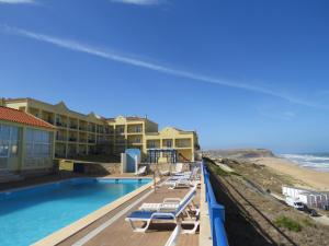 widok na ośrodek z basenem i plażę w obiekcie Hotel Apartamento Praia Azul w mieście Silveira