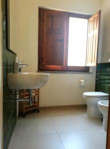 łazienka z umywalką, toaletą i oknem w obiekcie Belle Époque w mieście Iglesias
