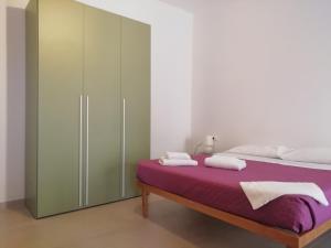 sypialnia z łóżkiem z fioletową pościelą i szafką w obiekcie Belle Époque w mieście Iglesias