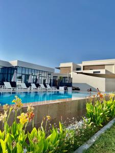 ラス・アル・ハイマにあるFamily vacation villa with private pool and access to beachのリゾート(ラウンジチェア付きのスイミングプールあり)