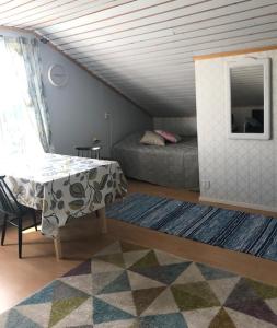 een woonkamer met een tafel en een bed bij Päivin pirtti - Pirttikahvila ja B&B in Luosto