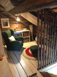 a living room with a green couch and a book shelf at Päivin pirtti - Pirttikahvila ja B&B in Luosto