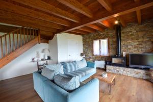 a living room with a blue couch and a tv at El turó d'Enveig in Enveitg