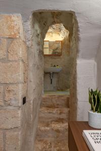 un bagno con lavandino in un muro di pietra di Il Quinto Elemento - Residence Of Charme a Ostuni