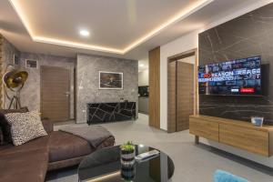 a living room with a couch and a television on a wall at Korzo Apartments Visoko in Visoko