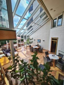 an indoor patio with tables and chairs and windows at Landhotel Henkenhof Willingen in Willingen