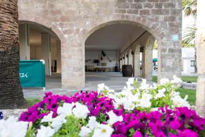 a courtyard with flowers in front of a building at Masseria Carrozzi in Melendugno