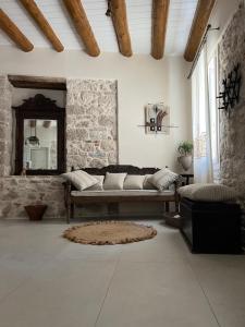 uma sala de estar com um sofá e um espelho em Stone Villa em Pythagoreio