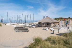 - une plage avec des chaises, un bâtiment et des voiliers dans l'établissement Villa Francois, à Nieuport