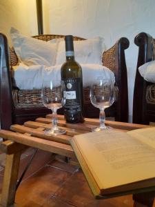 a bottle of wine sitting on a table with two glasses at La Tana del Riccio in Abbadia San Salvatore