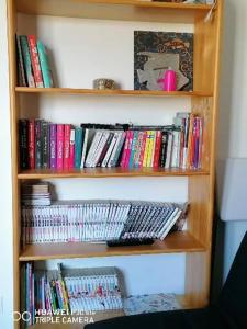 a book shelf filled with lots of books at Bain de soleil in Forcalquier