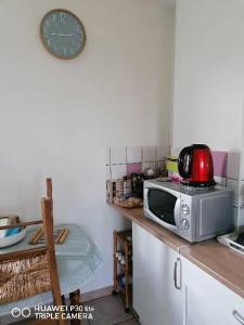 a kitchen with a microwave on top of a counter at Bain de soleil in Forcalquier