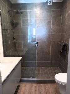 baño con ducha y puerta de cristal en Modern & Luxurious Beachfront Villa en Ballito