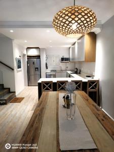 Modern & Luxurious Beachfront Villa في باليتو: مطبخ مع طاولة خشبية كبيرة عليها مزهرية