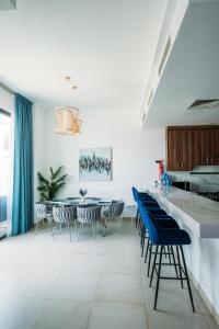 a dining room with blue chairs and a table at Relaxing villa with access to pool and beach in Ras al Khaimah