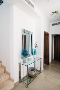 a hallway with a glass table and a mirror at Relaxing villa with access to pool and beach in Ras al Khaimah