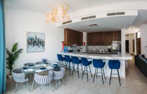 a kitchen and living room with a table and chairs at Relaxing villa with access to pool and beach in Ras al Khaimah