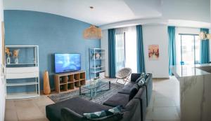 a living room with a couch and a tv at Relaxing villa with access to pool and beach in Ras al Khaimah